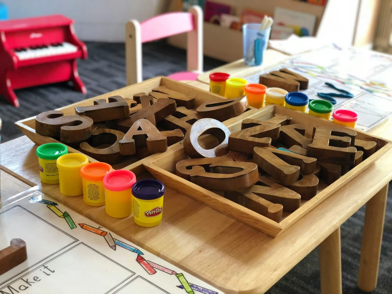 Wooden letter blocks and modeling clay on a classroom table