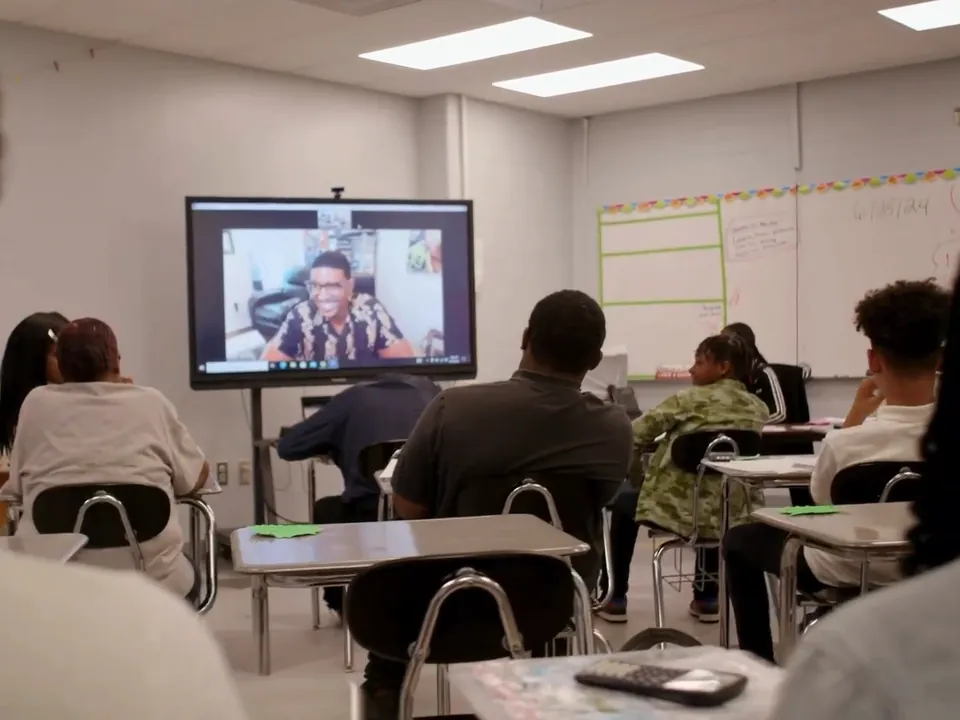 A certified Fullmind teacher on the classroom screen leads a live lesson for students at their desks